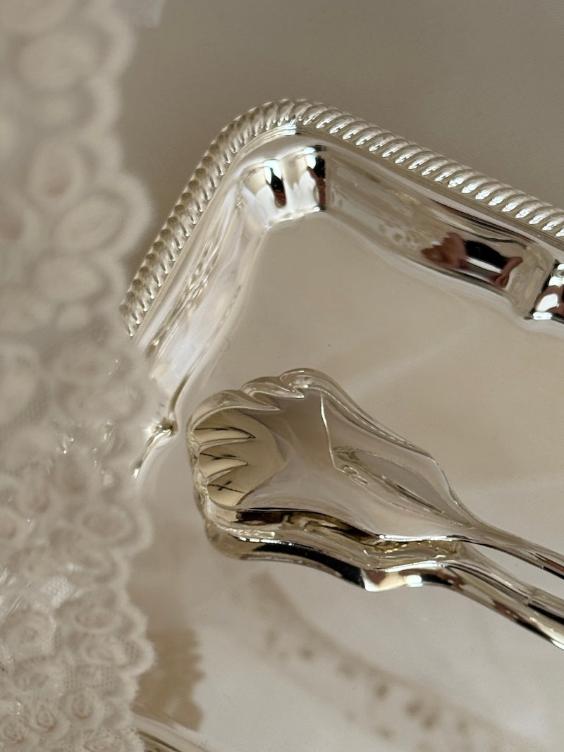 Close-up of a silver decorative item on a textured surface