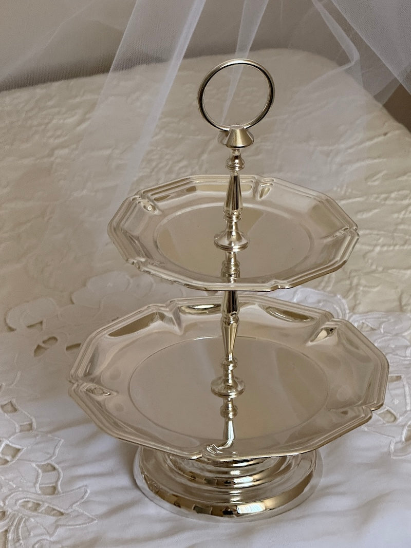 Silver two-tiered stand on a white lace tablecloth