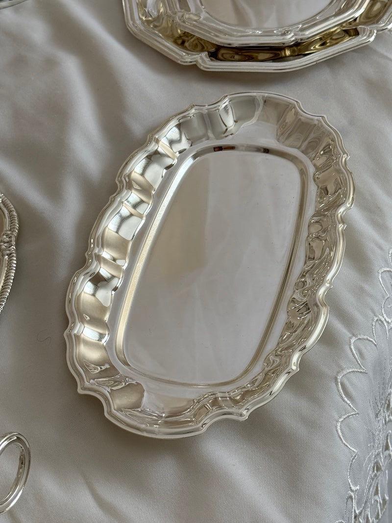 Silver decorative tray on a white fabric background